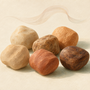 Editorial illustration of earthy bead color tones and a gentle scent ribbon